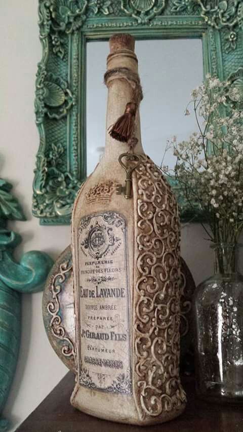 an old bottle sitting on top of a table next to a vase with flowers in it