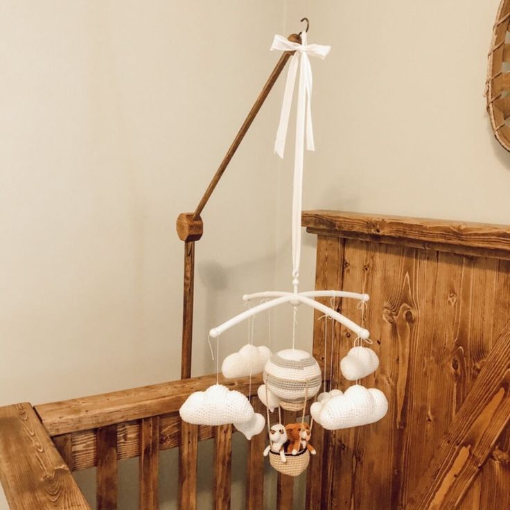 a baby crib with a mobile hanging from it's side