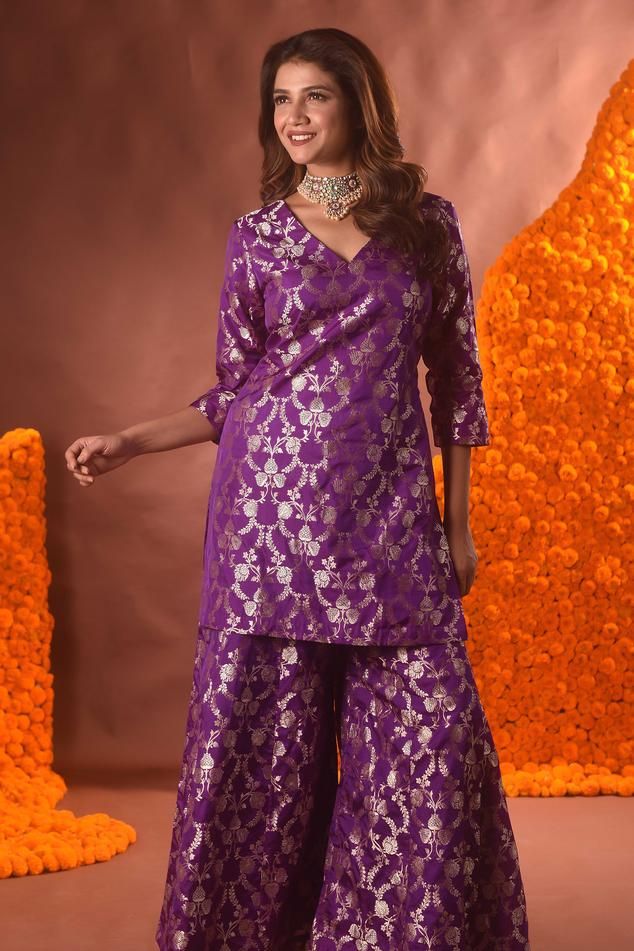 Purple banarasi silk kurta with floral pattern. Comes with sharara.
Components: 2
Type Of Work: Floral
Neckline: V Neck
Sleeve Type: Three quarter
Fabric: Banarasi silk
Color: Purple
Other Details: 
Note: Necklace worn by the model is not for sale.
Occasion: Mehendi and Haldi - Aza Fashions Luxury Purple Sharara With Straight Kurta, Purple Self Design Sharara, Purple Self-design Sharara, Festive Banarasi Silk Sharara With Straight Kurta, Elegant Brocade Palazzo Set With Straight Kurta, Festive Palazzo Set With Zari Weaving For Festivals, Fitted Purple Dola Silk Sharara, Jamawar Sets With Gota Work For Diwali, Festive Brocade Sharara With Self Design