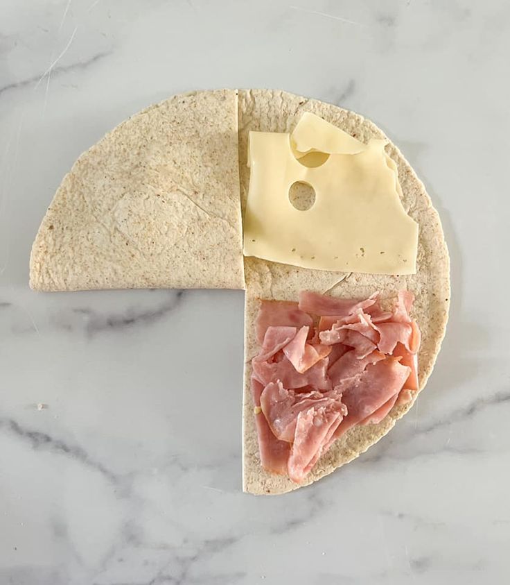 an open pita with ham and cheese on it