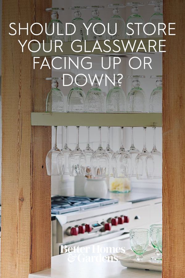 wine glasses are hanging on the wall in front of an oven and counter top with text that reads, should you store your glassware facing up or down?