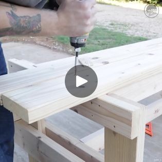 a man is using a drill to build a bench