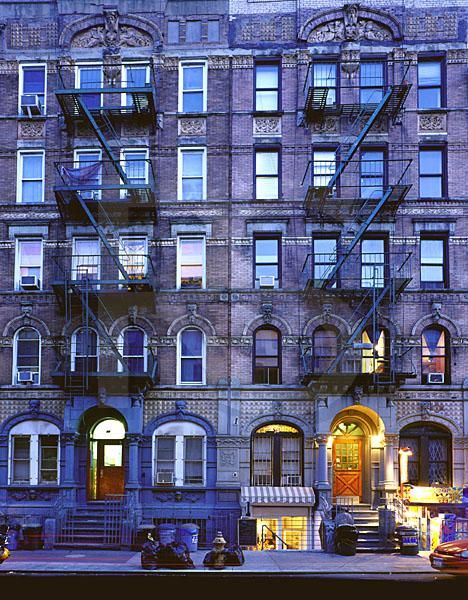 an apartment building with many windows and balconies on the top floor is lit up at night