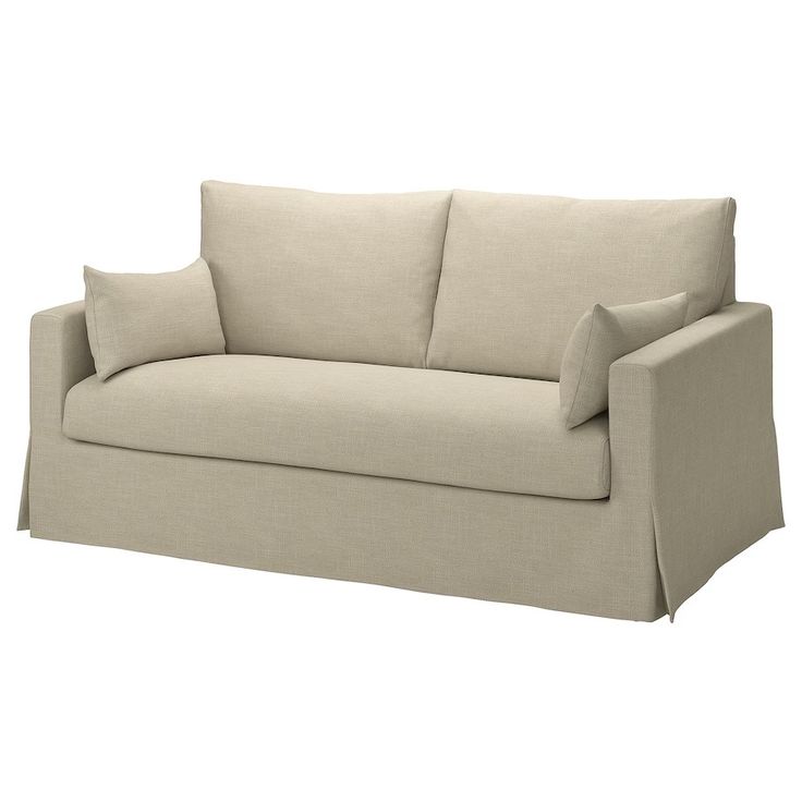 a beige couch with two pillows on the back and one arm folded over it's head