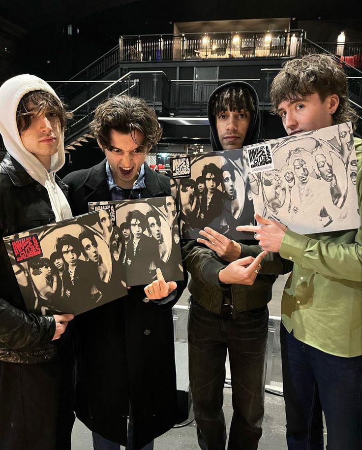 four people holding up pictures with faces drawn on them