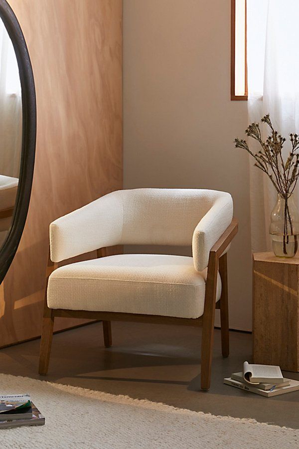 a white chair sitting in front of a mirror on top of a floor next to a table