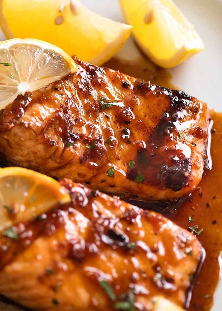 grilled chicken with lemons and sauce on a white plate