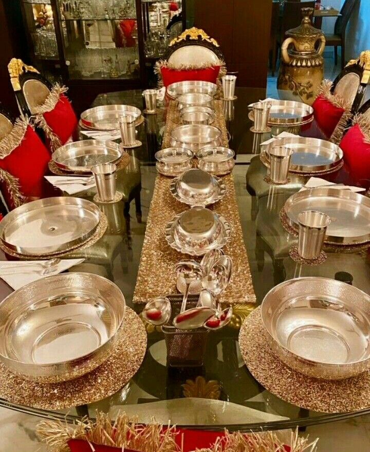 a glass table topped with lots of silver plates