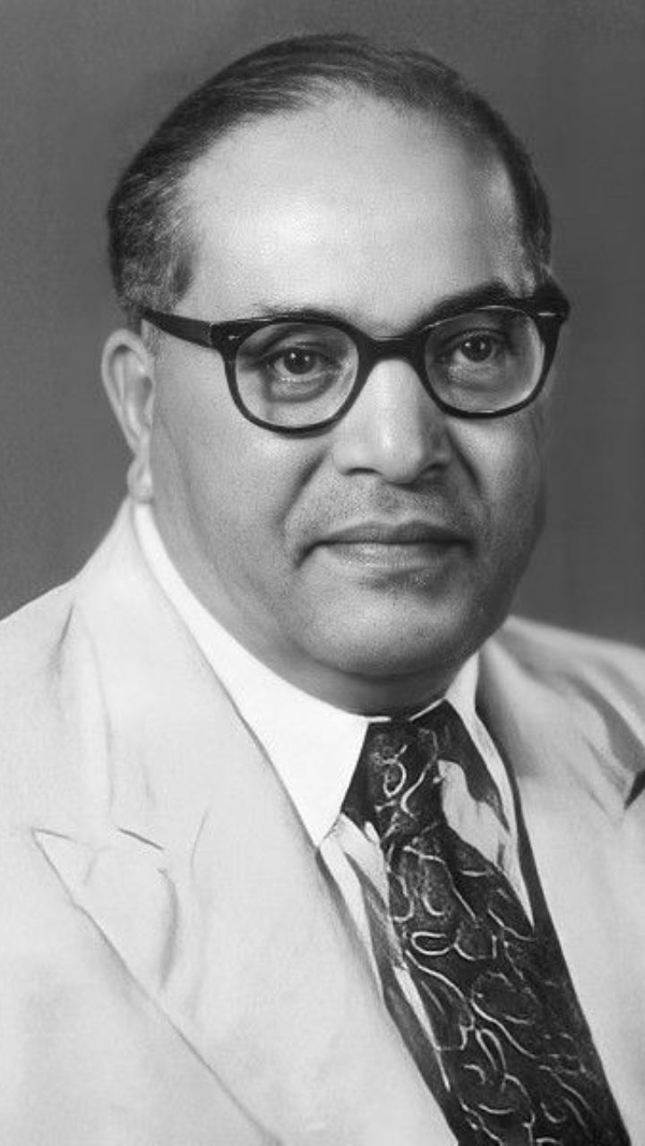 a black and white photo of a man in a suit with glasses on his face