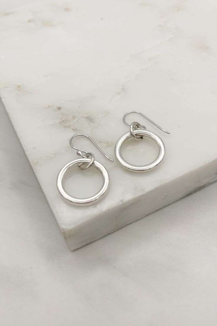 Elevate your style with our Nora Simple Silver Ring Dangle Earrings! These elegant earrings feature a stunning silver ring design that adds a touch of sophistication to any outfit. Perfect for any occasion, these earrings are sure to be a wardrobe essential. Description:- Simple, Sleek Design- Lightweight- Made by Hand- French Hook Earring AttachmentsDimensions:- Ring Diameter: Approx. 0.75"- Earring Length: 1.25" Classic Silver Circle Earrings, Everyday Open Circle Earrings With Ear Wire, Simple Round Silver Earrings, Nickel-free Sterling Silver Open Circle Earrings, Silver Round Dainty Earrings, Nickel Free Circular Earrings, Silver Single Circular Earring, Silver Dainty Round Earrings, Silver Single Open Circle Earring