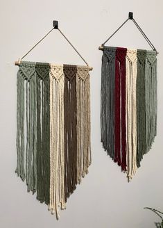 two wall hangings with different colored tassels attached to the side of them