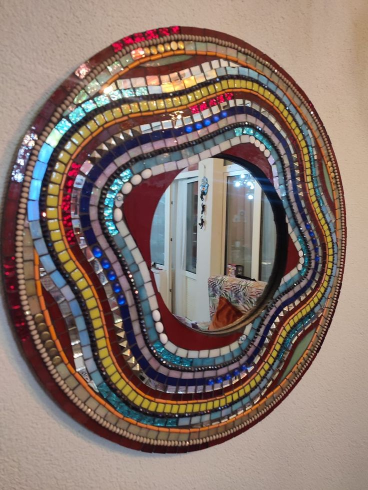 a circular mirror with multicolored glass on it