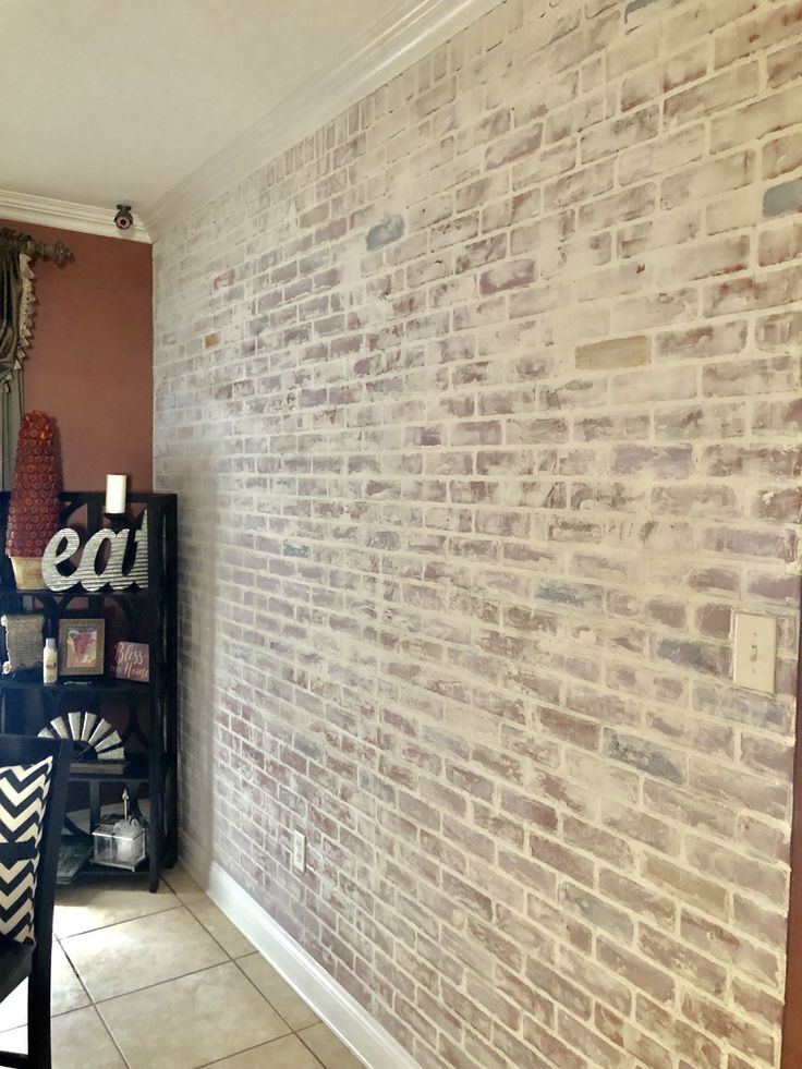 a room with a brick wall and white tile flooring