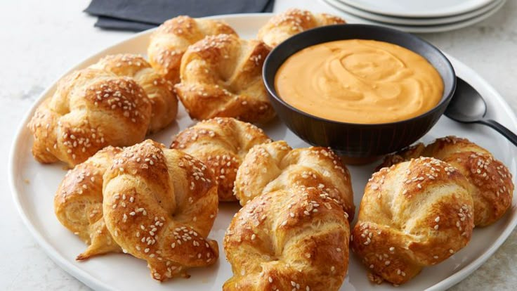 a white plate topped with croissants and dipping sauce