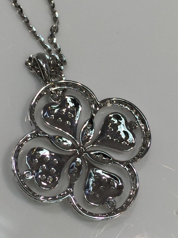 Beautiful Fancy Clover or Floral Design Diamond Pendant in 14K white gold with gem quality diamonds. Approximately F-Color, VS Clarity. Total Weight of .60 Carats of Diamonds. Lovely High Polished Back added to show attention to detail as well as style. White Gold Chain in 14 Karat Gold with Lobster Clasp included. Chain is of High Shine Cable Design. Silver Flower Shaped Jewelry With Diamond Accents, Diamond Flower Necklace For Anniversary, White Diamond Necklace With Flower Shape And Diamond Accents, White Diamond Necklace With Flower-shaped Accents, Diamond White Jewelry With Flower Shape And Diamond Accents, White Diamond Necklace With Flower Shape Accents, Silver Diamond Necklace With Flower Design, Flower-shaped Diamond Necklace With Single Cut Diamonds, White Gold Cubic Zirconia Flower Shaped Diamond Necklace