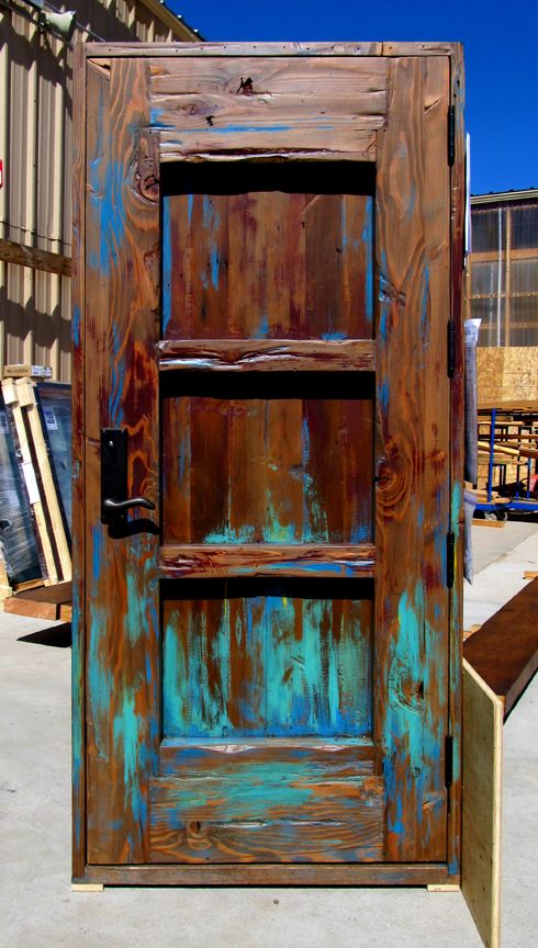 an old wooden door with blue paint on the outside and brown wood in the inside