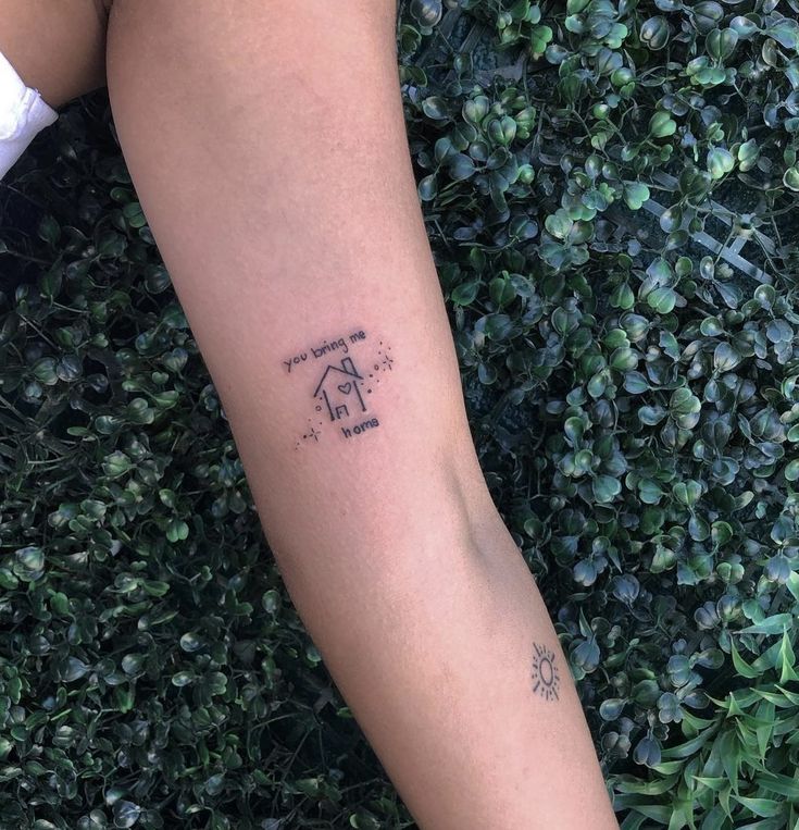 a person's arm with a tattoo on it and a house in the middle