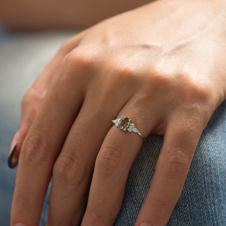 a close up of a person's hand with a diamond ring on their finger