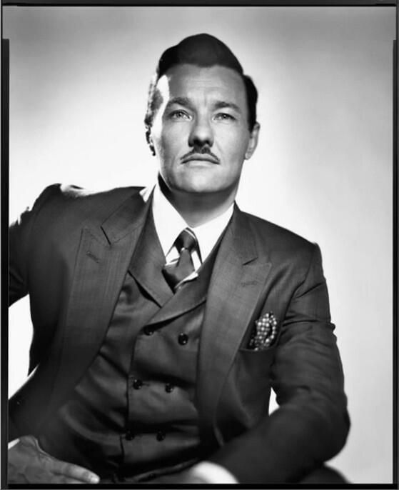 an old photo of a man in a suit and tie with a moustache on his face