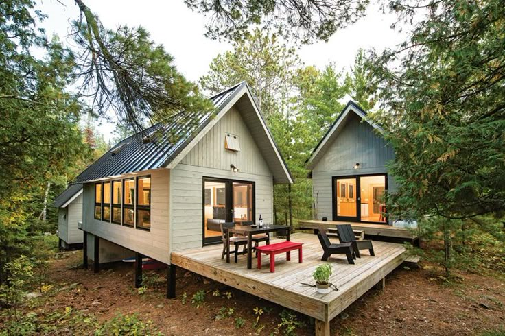 two tiny houses sitting on top of a wooden deck