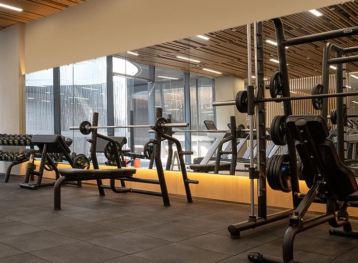 there are many gym equipment in this large room that is very clean and ready to use