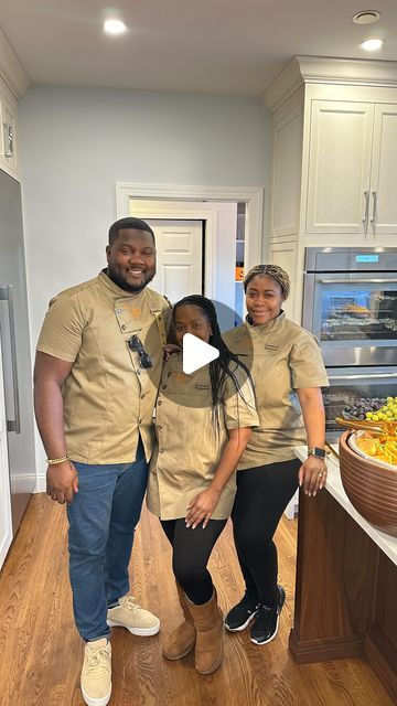 three people standing in front of a bowl of fruit