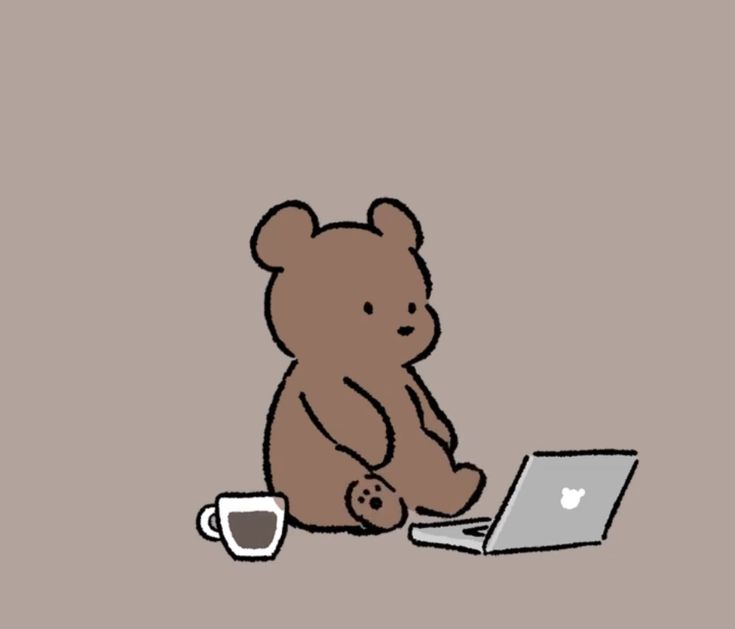 a brown teddy bear sitting at a table with a laptop and coffee cup in front of it