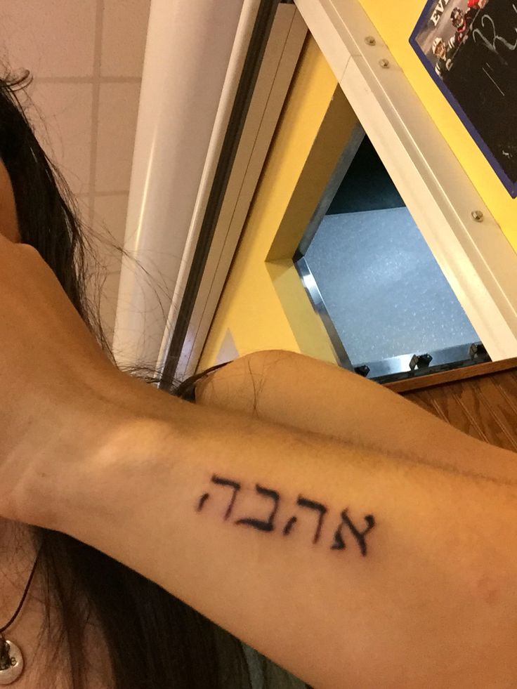 a woman with a hebrew tattoo on her arm