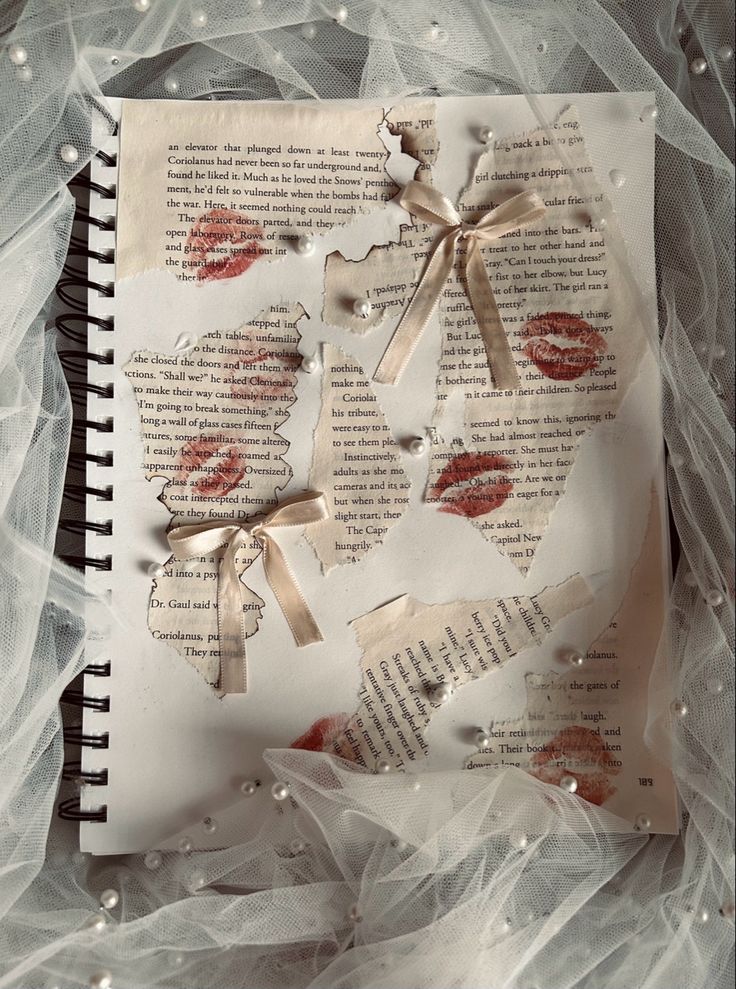 an open book with torn pages and ribbons