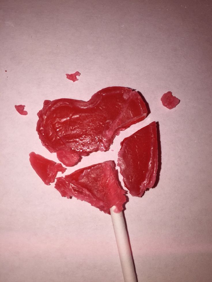 two heart shaped lollipops sitting on top of each other with hearts cut out of them