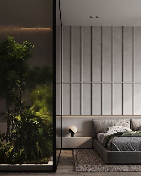 a bedroom with a large bed next to a tall plant in the middle of it