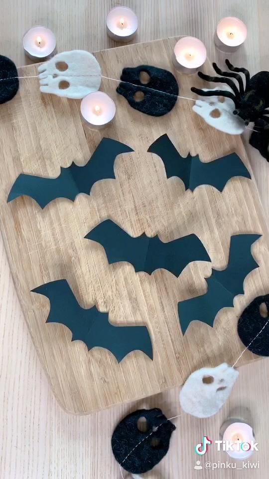 a wooden cutting board topped with bats and candles