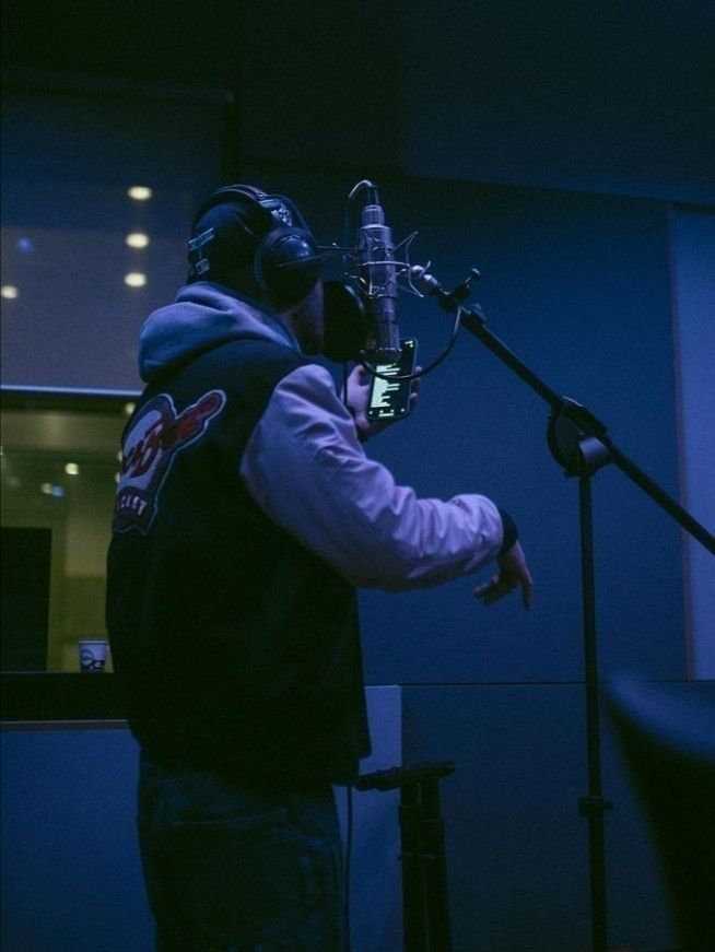 a man wearing a hoodie and holding a microphone