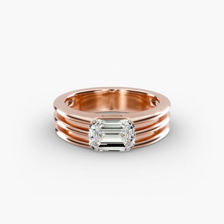 an 18k rose gold ring set with two emerald cut diamonds