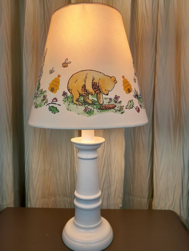 a lamp that is sitting on top of a table with a bear painted on it