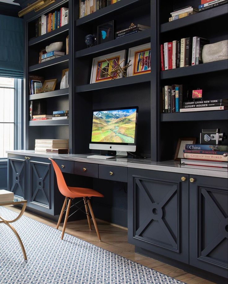 a living room filled with lots of bookshelves next to a desk and chair