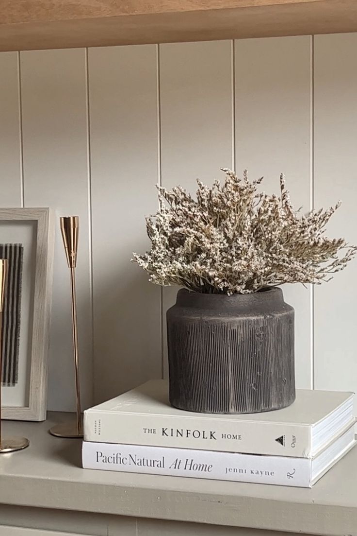 two books and a vase on a shelf