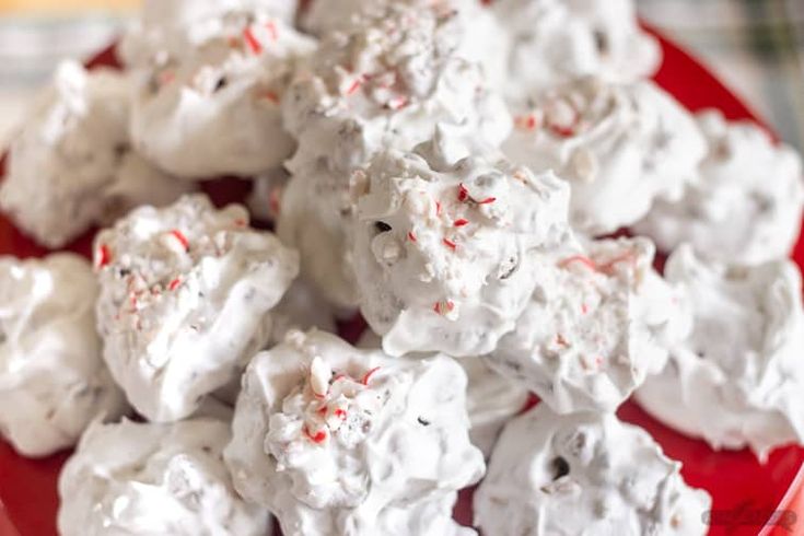 a red plate topped with marshmallows on top of a table