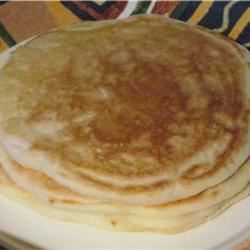 three pancakes are stacked on a white plate