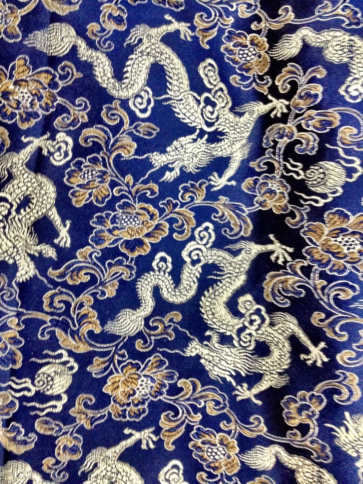 a blue and gold fabric with dragon designs on it's side, as well as an image of two lions