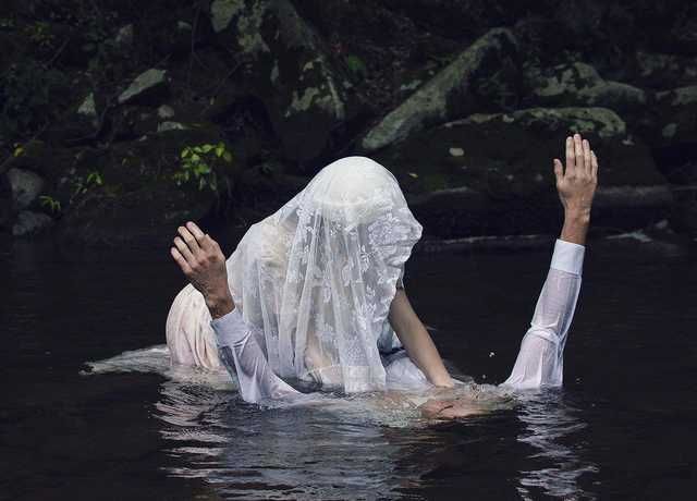 a woman floating in the water with her hands up