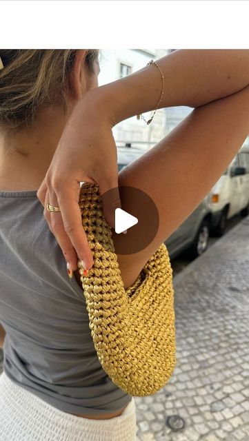 a woman holding onto a yellow purse on the street