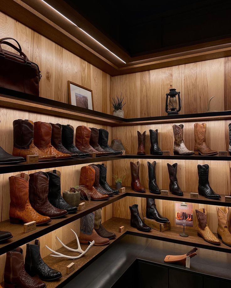 there are many pairs of cowboy boots on the shelves in this room, all lined up