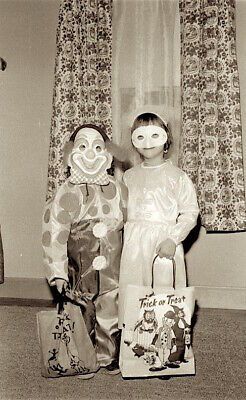 two clowns standing next to each other in front of a window with drapes