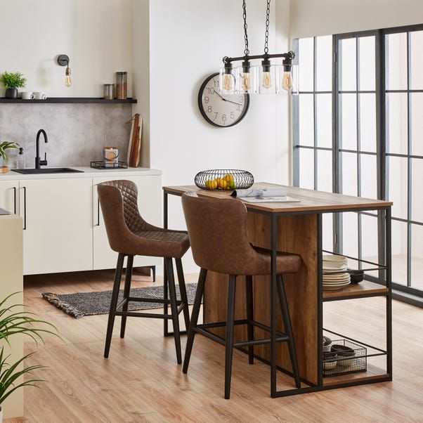 a kitchen table with two chairs and a clock on the wall