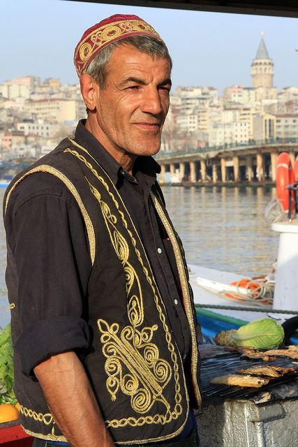 a man standing in front of some watermelon on the side of a river