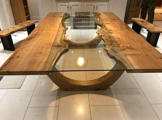 a wooden table with glass top in a room filled with white tile flooring and wood benches