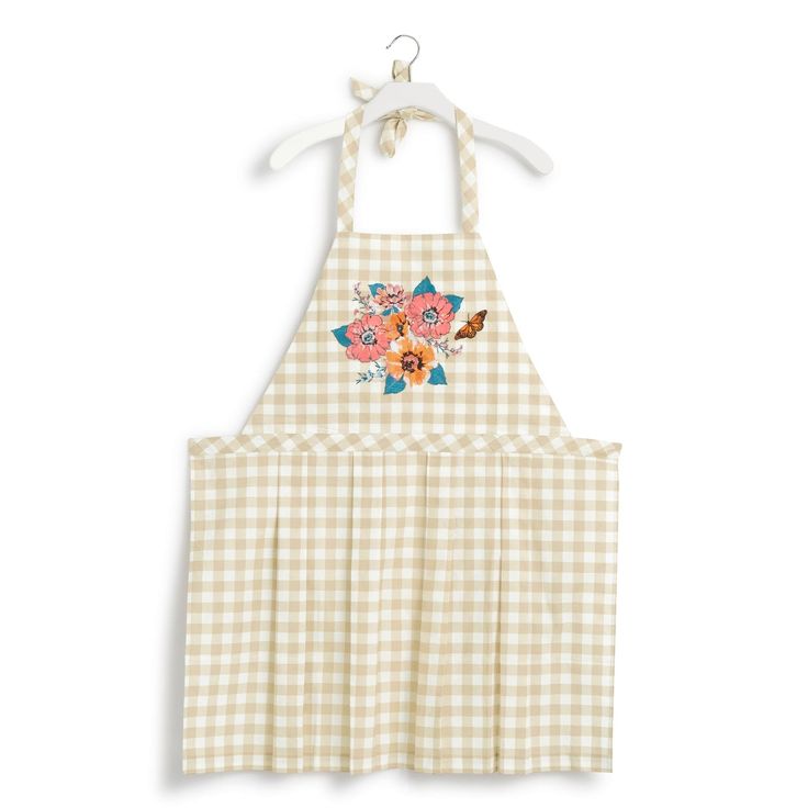 a white and yellow apron with flowers on the front, hanging from a hanger