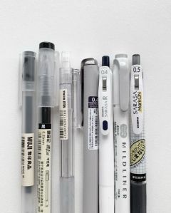 several pens are lined up next to each other on a white surface with black ink