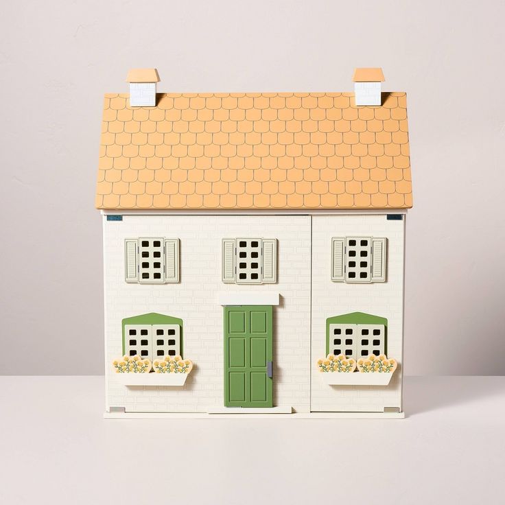 a doll house with green doors and windows